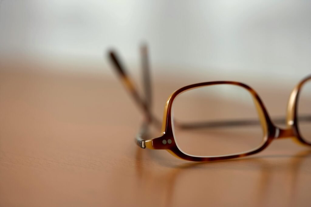 A close-up view of stylish brown eyeglasses resting on a wooden table.